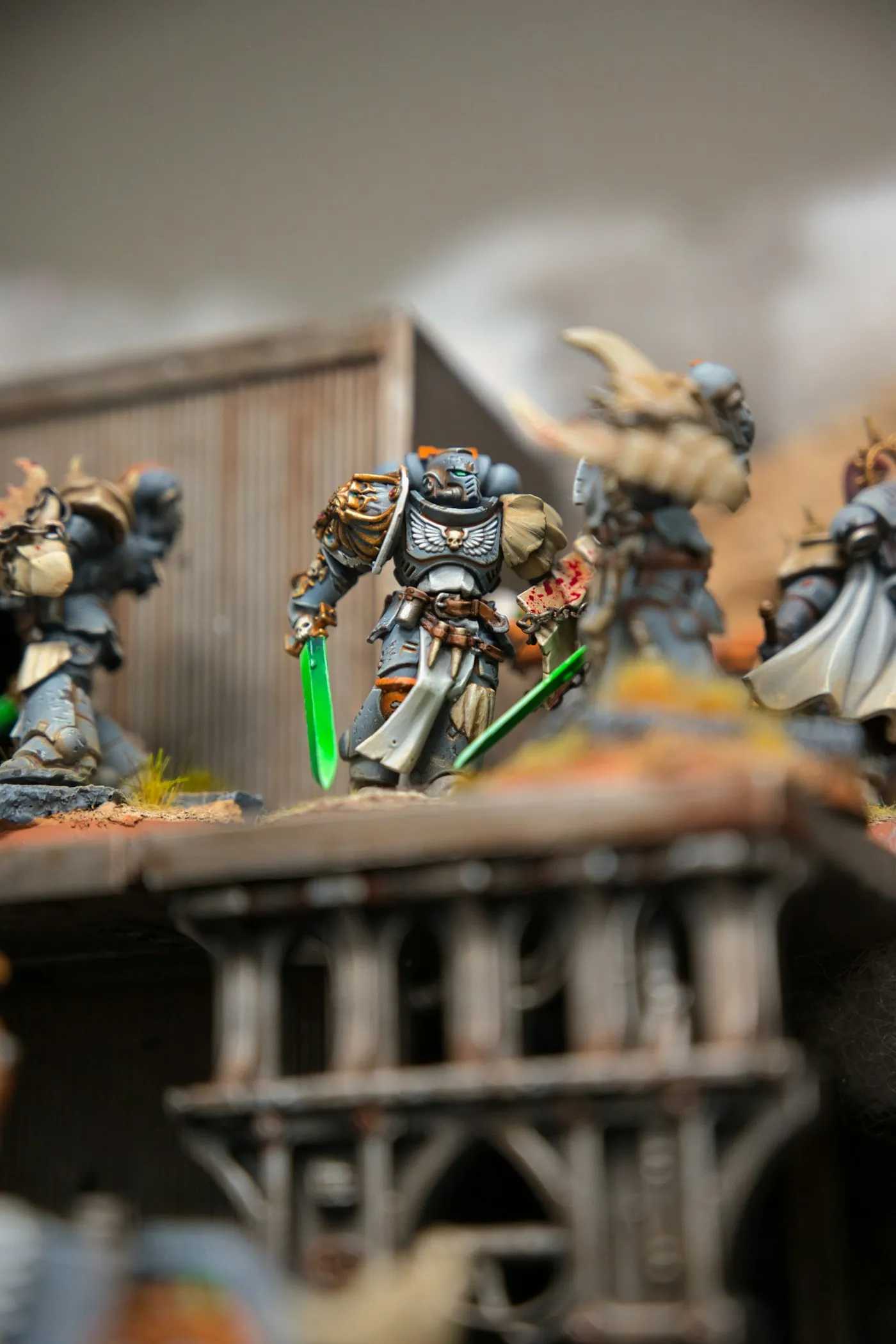 Power-armored space marine miniature wielding glowing green energy swords on a ruined battlefield.